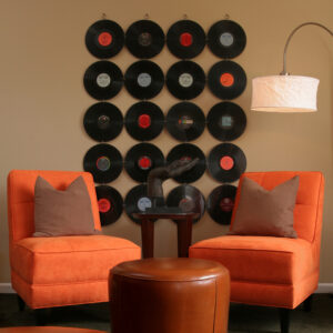 records on a beige wall with two orange club chairs