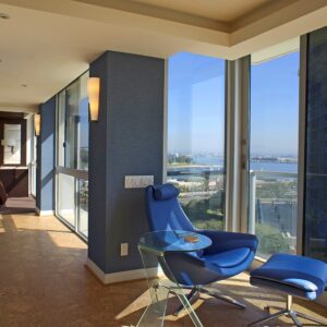 residential interior showing a blue chair overlooks the scenic view of the ocean
