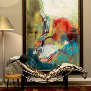 a lounge chair situated in front of abstract art with reds blues and yellows
